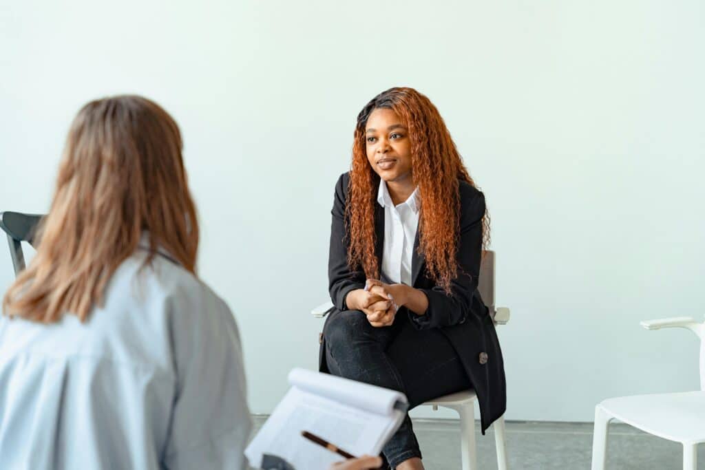 Therapist interacting with client during a counseling session indoors.